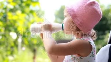 小女孩喝一瓶牛奶或开菲尔，微笑着，<strong>露出</strong>了酸奶的白胡子。