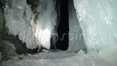 在贝加尔湖冰洞旅行的人。 去冬岛旅行。 背包客正在冰窟散步。 旅行者看着