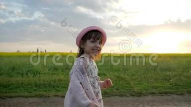 在背光中奔跑的女孩子肖像，微笑的女孩，沿着田野的道路奔跑，快乐的孩子在城外玩