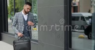 一个年轻英俊的商人学生穿着西装，带着一个公文包，在车站，在机场或商务场合