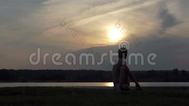 年轻的瑜伽士坐在一只鹰的阿萨纳在斯洛文尼亚的湖岸