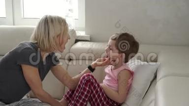 妈妈检查她生病儿子的体温。 患病儿童发烧及生病卧床