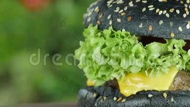 牛肉和黄瓜的汉堡，木制的<strong>生菜叶</strong>子和蔬菜背景模糊的黑色面包