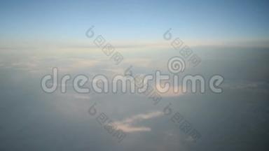 在阳光明媚的日子里，透过喷气式飞机的窗户看到了蓝色和白色的云。 高清视频高清晰度
