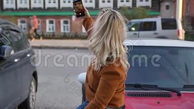 年轻快乐的女人在街上的智能手机上拍新照片。 在路上为<strong>社交网络</strong>做自拍的<strong>女孩</strong>