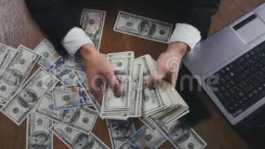 一个商人坐在办公室的桌子上数着钱，紧紧地握住他的手。 <strong>薪酬</strong>或利润的概念..
