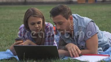 两个<strong>学生</strong>在草坪上用笔记本电脑<strong>讨论</strong>一些事情