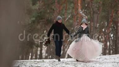 户外<strong>冬季</strong>拍摄，年轻的新婚夫妇在<strong>雪天</strong>松林中奔跑，玩得开心