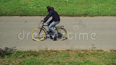 骑自行车上下班.. 一个骑自行车的人骑自行车在自行车道上