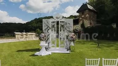 绿色公园的自然婚礼。 装饰婚礼与滑块运动。 婚礼拱门和鲜花