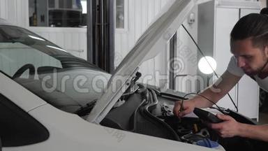 专家机械师站在敞开式引擎盖附近，检查汽车系统的布线，发动机检查，故障诊断，
