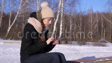 冬季森林、晴天智能手机上的妇女浏览图片、文字、号码