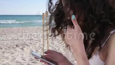 暑假用手机交流，<strong>女孩</strong>用小工具浏览<strong>社交网络</strong>，沙滩上的年轻女子