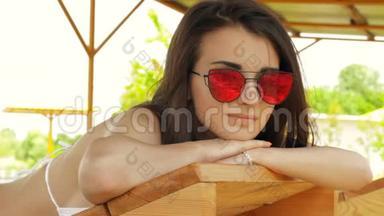 戴眼镜的黑发女人在海滩上晒太阳