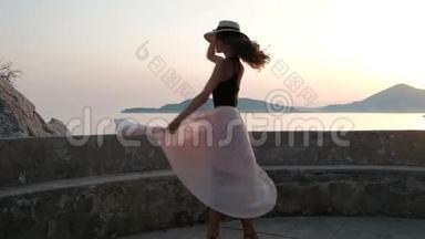 一个穿着高跟鞋和<strong>浅色</strong>连衣裙的漂亮女人在台上戴着帽子<strong>优雅</strong>地跳舞