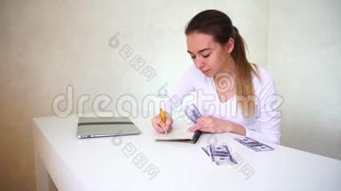 年轻的新娘坐在<strong>桌</strong>子旁，手提电脑，分发<strong>结婚</strong>的钱