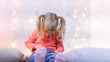 小女孩<strong>坐在</strong>房间的<strong>地板上</strong>，装饰着圣诞节的装饰，在电话里玩游戏。