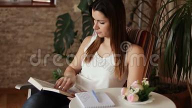 年轻漂亮的女人<strong>看书</strong>和做笔记。 坐在椅子上<strong>看书</strong>的女人。