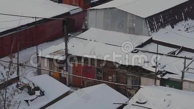 冬季日落时，莫斯科的车库合作区的旧消声器店被雪覆盖到大宿舍区。