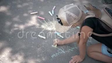 一个小女孩在沥青上画粉笔。 <strong>孩子</strong>在公园里<strong>晒太阳</strong>..