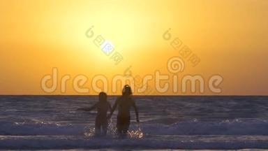 一对夫妇在日落时在海滩上奔跑和享受。 幸福的男人和女人牵着手在海边奔跑