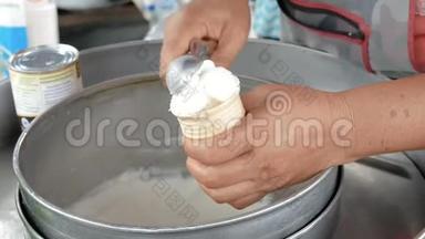 女人用勺子把冰淇淋舀到<strong>蛋筒</strong>里