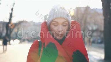 在一个阳光明媚的冬日，穿着红色夹克的漂亮女人站在满是雪的街道上