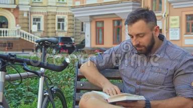 骑自行车的人在长凳上翻书