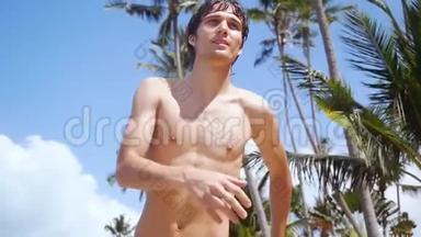 在阳光明媚的日子里，年轻英俊的快乐男子在海滩上<strong>奔跑</strong>，在蓝天上的棕榈树上<strong>奔跑</strong>