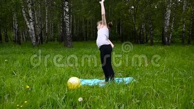 年轻漂亮的青少年女孩在户外练习健身<strong>运动</strong>，在夏天的公园里。 高清拍摄静态<strong>摄像机</strong>..