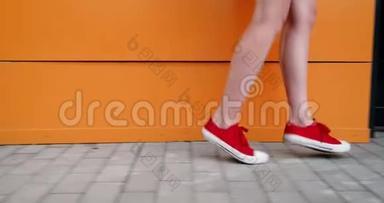 一个穿着深红色运动鞋的年轻女子的腿