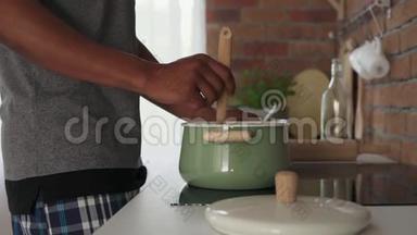 非洲男人在厨房里用锅煮开水，慢镜头