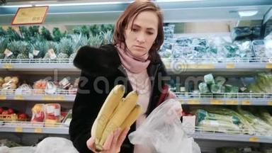 超市里的女人选择香蕉。 一个穿黑色皮<strong>毛大衣</strong>的女孩正在商店买香蕉。