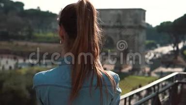一位年轻的黑发女游客在智能手机上拍摄康斯坦丁拱门和意大利罗马的照片，微笑着。 慢动作。