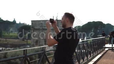 人类游客在意大利罗马的智能手机上拍摄风景照片。 康斯坦丁的拱门在背景上。 慢动作。