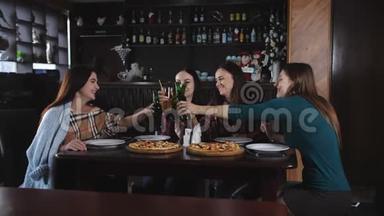 一群漂亮的女孩在披萨店里叮叮当当地喝着啤酒。