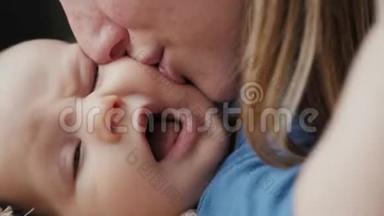 一个美丽的女人<strong>亲吻</strong>婴儿的肖像，母亲<strong>亲吻</strong>她新生的婴儿
