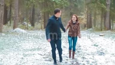 一对冬雪针叶林散步男女牵手在雪地公园慢动作