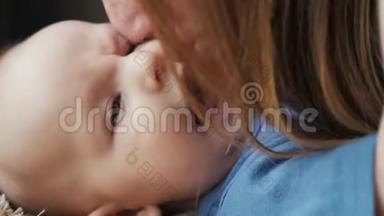 一个美丽的女人亲吻婴儿的肖像，母亲亲吻她新生的婴儿