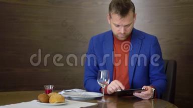 帅哥在餐厅就餐，在等待<strong>点餐</strong>时使用平板电脑