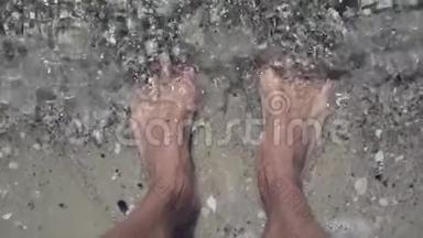 <strong>男</strong>子脚在海边的海滩上，高高的视野。 人站在海边，脚上沾满了水。 <strong>夏季</strong>和