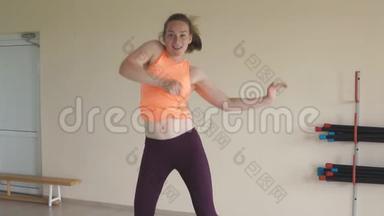年轻女孩在健身房或工作室跳尊巴舞。 慢动作。 健身、体育、舞蹈和生活方式概念