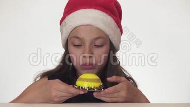 戴着圣诞老人帽子的漂亮女孩，有<strong>胃口</strong>，很高兴在白色背景股票上吃生日蛋糕