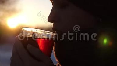 年轻<strong>美丽</strong>的女人在<strong>夕阳美丽</strong>的太阳下喝着透明玻璃的茶。