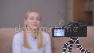 女视频录像机在坐在沙发上时在镜头前拍摄vlog