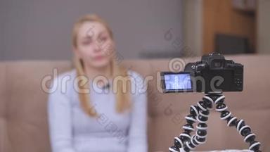 女视频录像机在坐在沙发上时在镜头前拍摄<strong>vlog</strong>