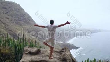 适合年轻人在山上为海洋练习太阳敬礼瑜伽。 年轻人喜欢冥想和瑜伽。 健身健身