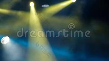 音乐会灯光和烟雾。 <strong>舞台</strong>上明亮的黄色和<strong>蓝色</strong>的探照灯。 模糊的。 背景录像。