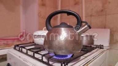 天然气火焰上的水壶特写镜头。 晚上喝茶。 有开水的茶壶。