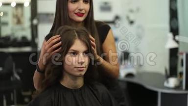 理发师给女人做发型。 剪发特写.. 剪刀和梳子在发型师。 一头漂亮的头发